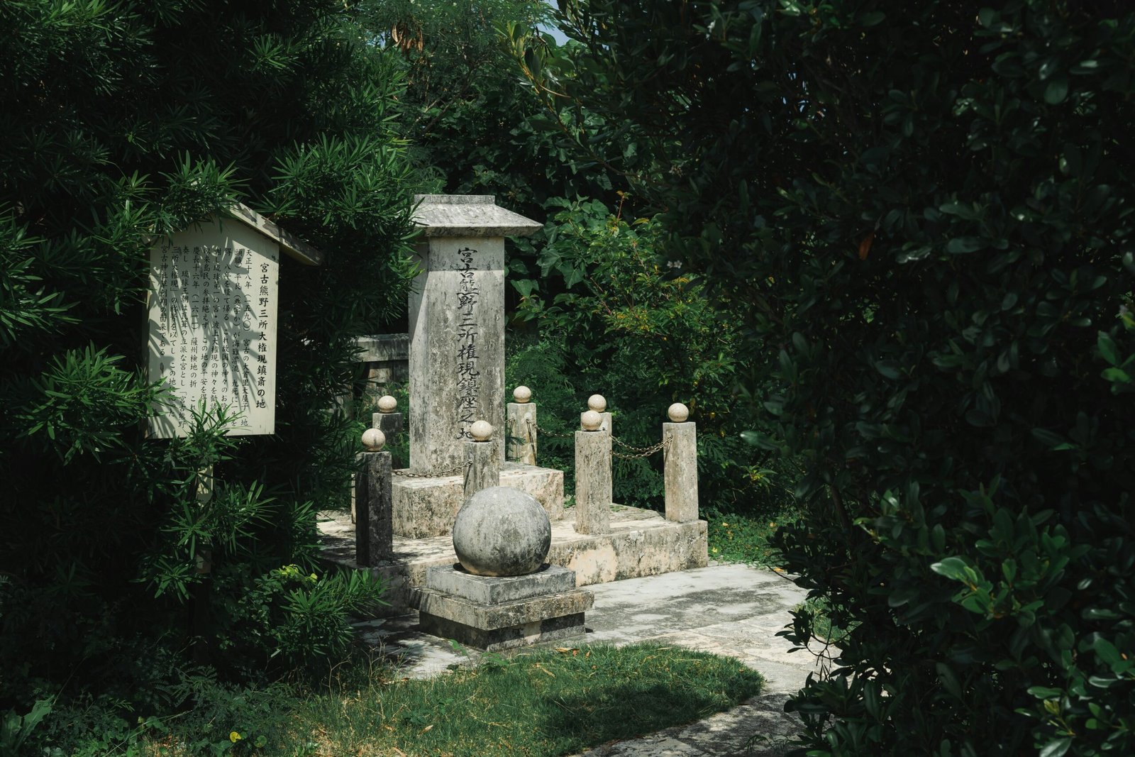 a couple of stone statues sitting in the middle of a park